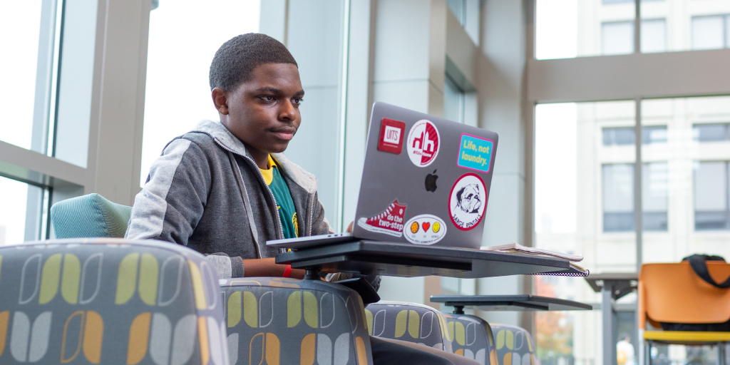 A student looking up information on their laptop.